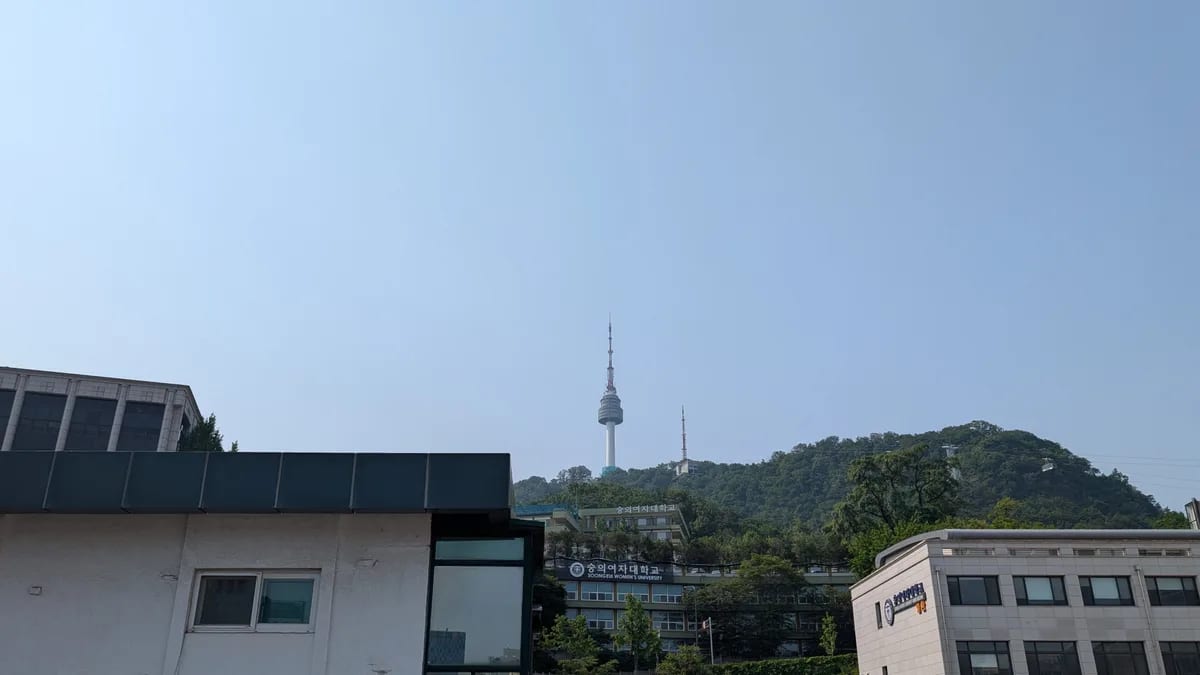 N Seoul Tower on Namsan hill seen from the hostel rooftop with a clear blue sky