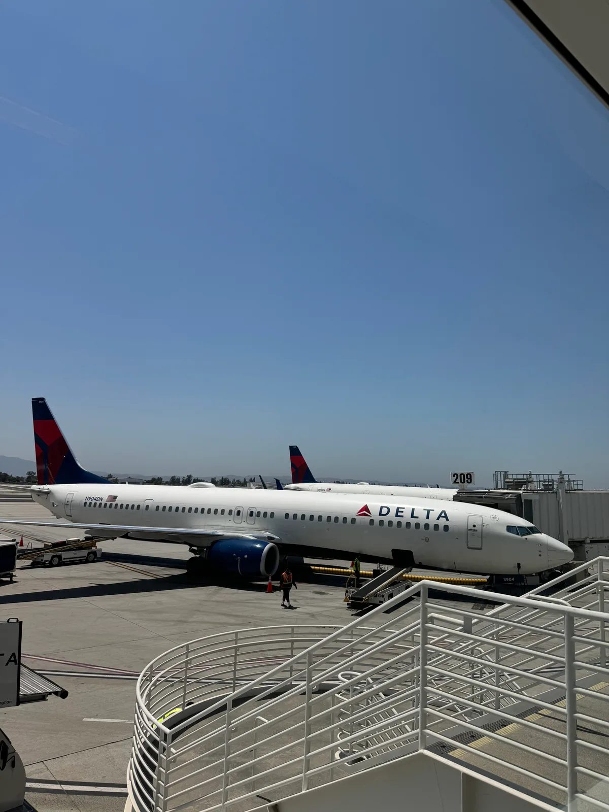 Delta Boeing 737 at Ontario International Airport gate under clear blue sky, ready for Chicago flight