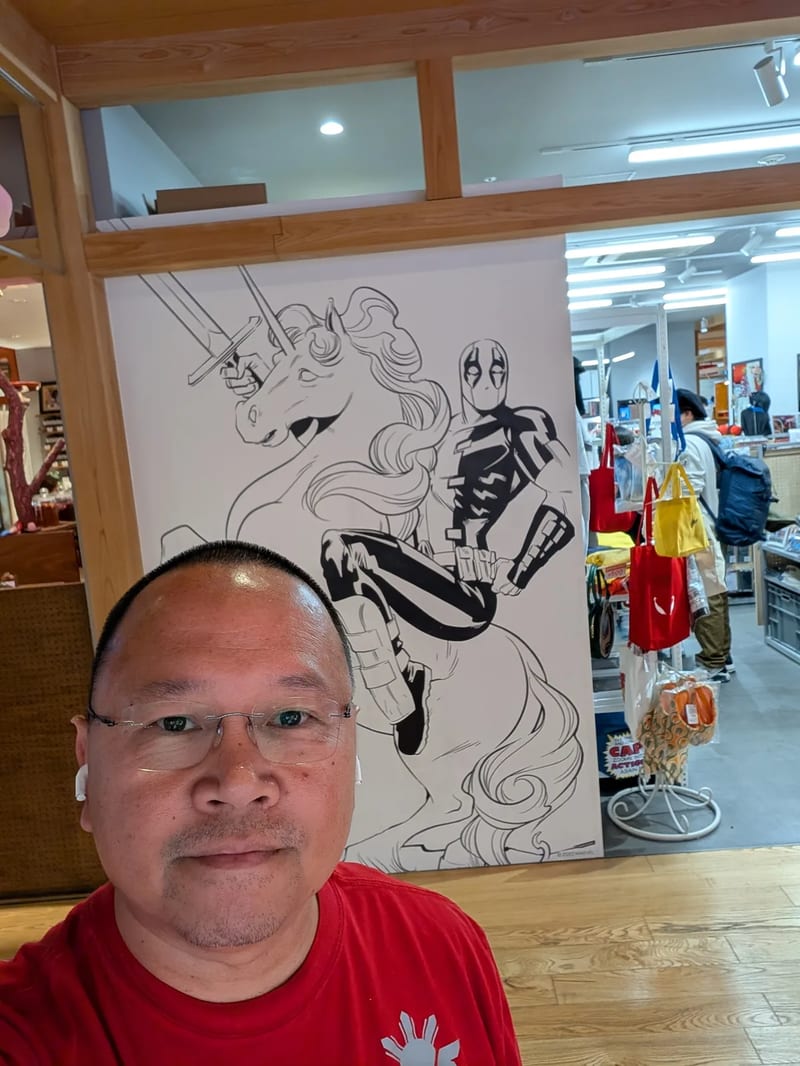 Selfie in front of a large Deadpool riding a unicorn illustration inside a pop-up collectibles store in Shibuya, Tokyo, Japan