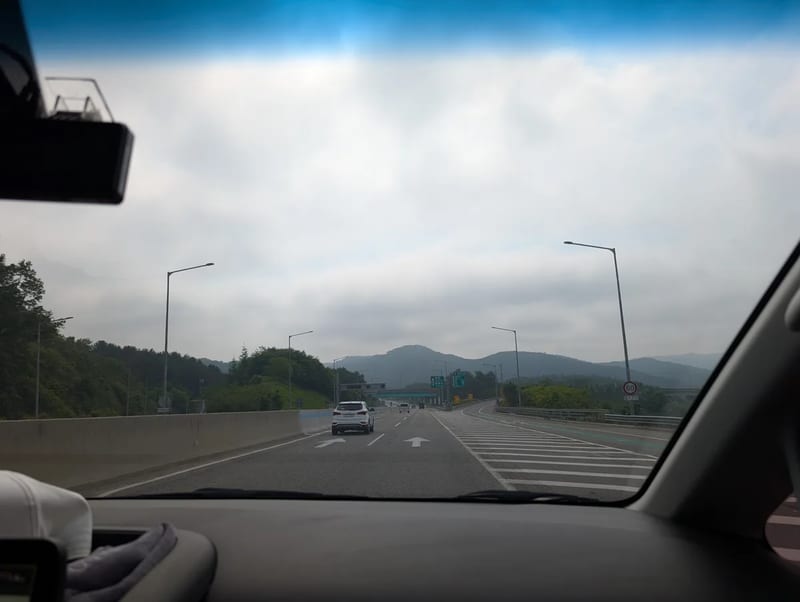 View through the windshield of a car on a multi-lane highway under a cloudy sky on the drive toward Alpaca World in Gangwon Province, South Korea
