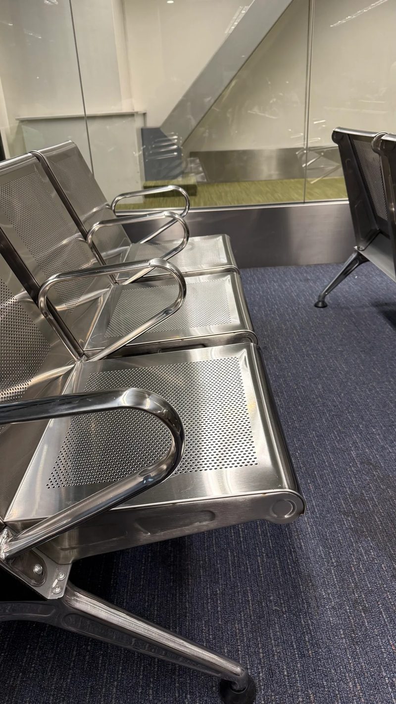 Rows of hard stainless steel waiting seats at the airport gate