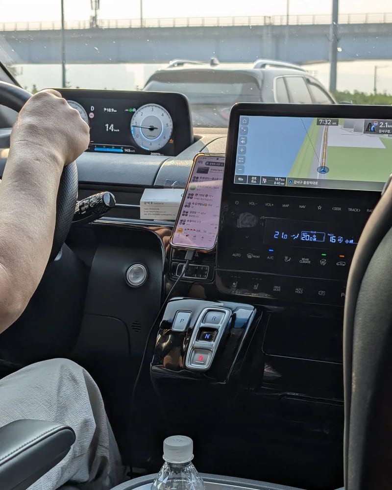 Driver's side of the Hyundai Staria with the digital gauge cluster and a large navigation screen showing the route into Seoul