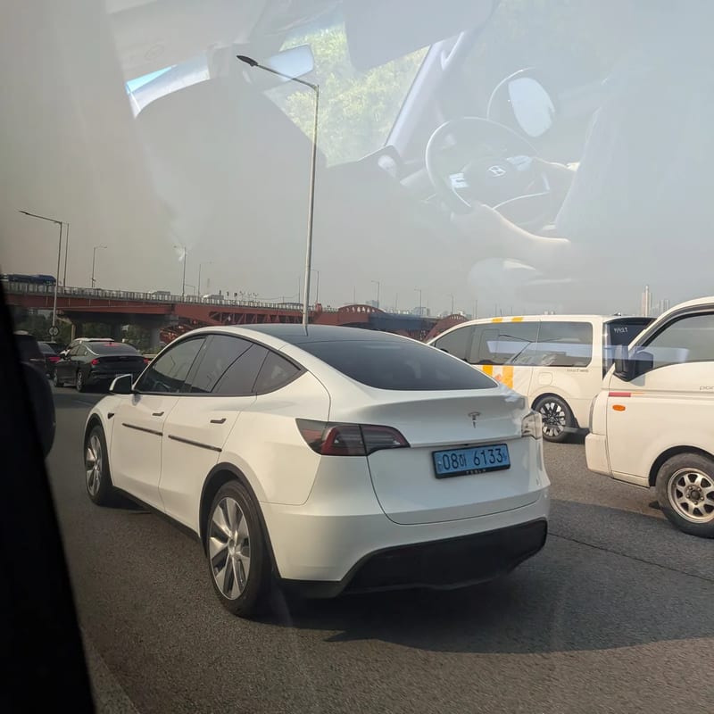 A white Tesla Model Y with a Korean licence plate in traffic on the way into Seoul