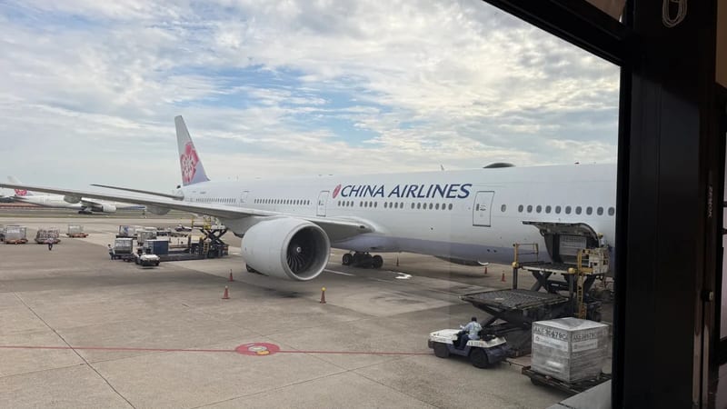 China Airlines Boeing 777 at the gate with ground crew loading cargo