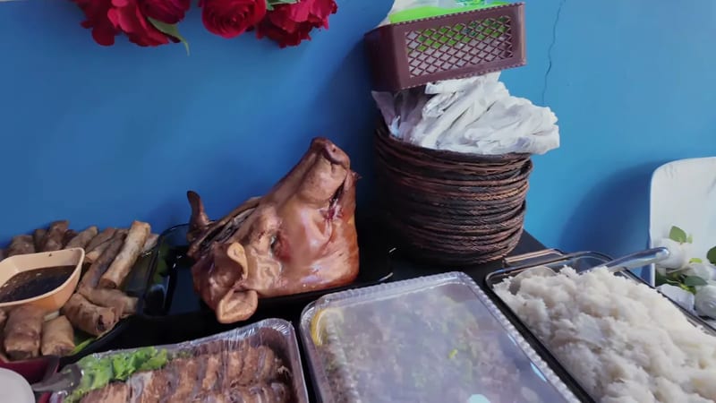 Filipino party spread with roast pig, lumpia, fish and rice