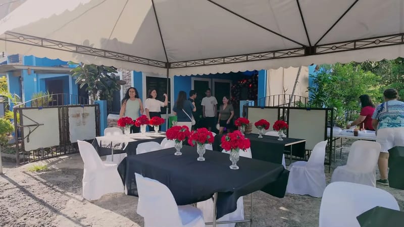 Outdoor surprise birthday party setup with tented tables and red roses