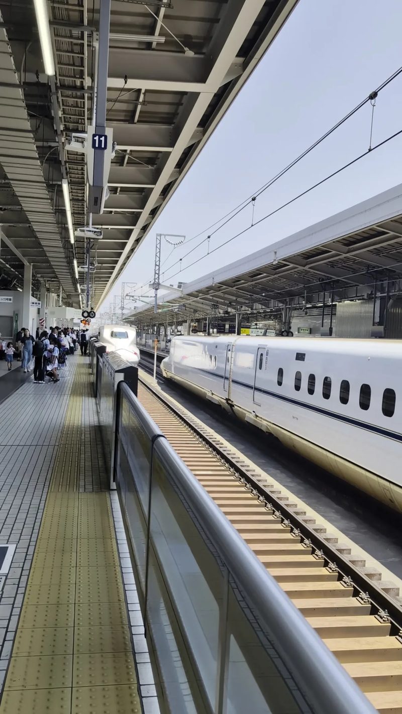 Shinkansen bullet train arriving at Shin-Osaka Station platform, Japan.