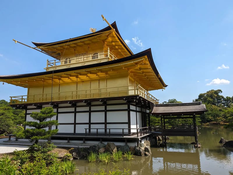 Kinkaku-ji Golden Pavilion with wooden walkway over pond in Kyoto, Japan.