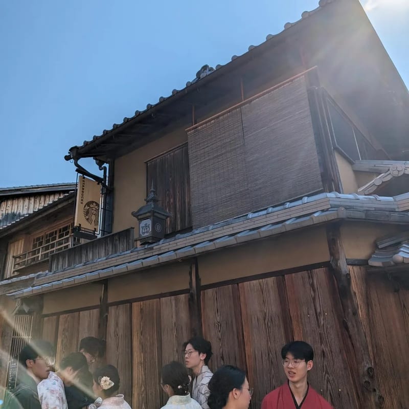 Traditional Japanese Starbucks exterior in Kyoto with wooden facade and people outside.