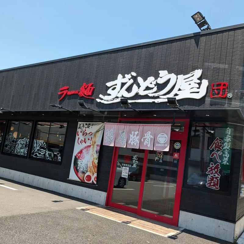 Exterior of Zundo-Ya ramen restaurant with black facade and red entrance in Kyoto, Japan.