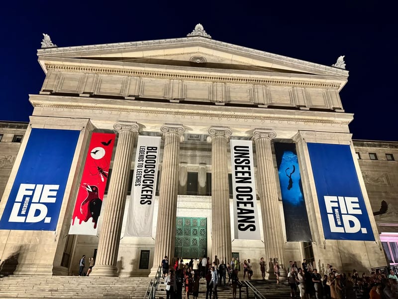 Field Museum in Chicago, Illinois exterior at night with illuminated grand columns and event banners for Blood Suckers and Unseen Oceans exhibits
