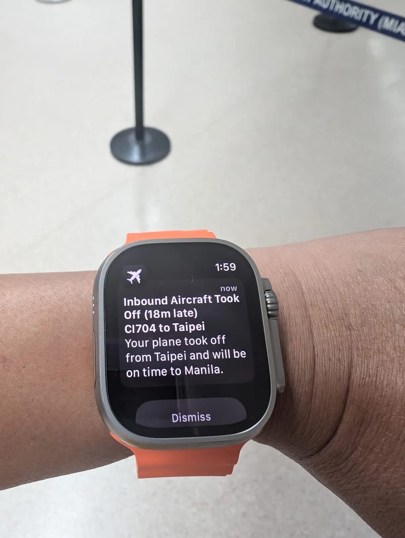 Apple Watch Ultra displaying a flight tracking notification for China Airlines CI704 from Taipei, showing an 18-minute late departure but on-time arrival at Manila, Philippines.