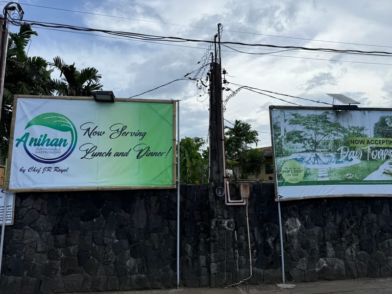 Anihan Sustainable Gastronomy, by Chef JR Royol Anihan Sustainable Gastronomy by Chef JR Royol banner and a day tour banner on a stone wall