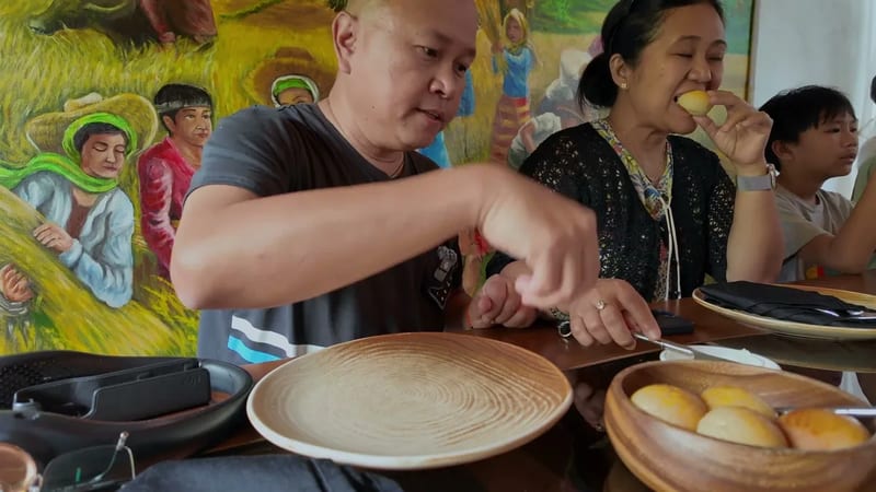 Bread and kesong puti to start Wooden plates with soft bread rolls served with white cheese in front of a farmers mural