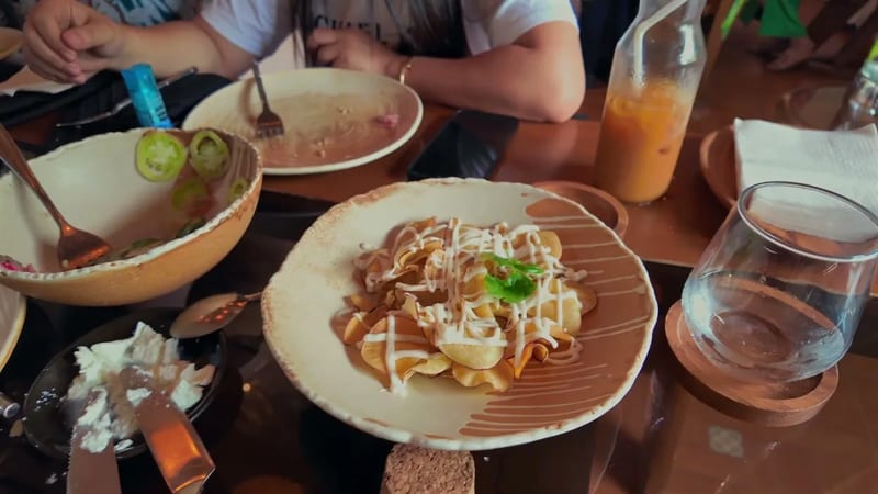 Camote chips with a vinegar mayo drizzle Plate of camote sweet potato chips drizzled with vinegar mayonnaise on a ceramic dish