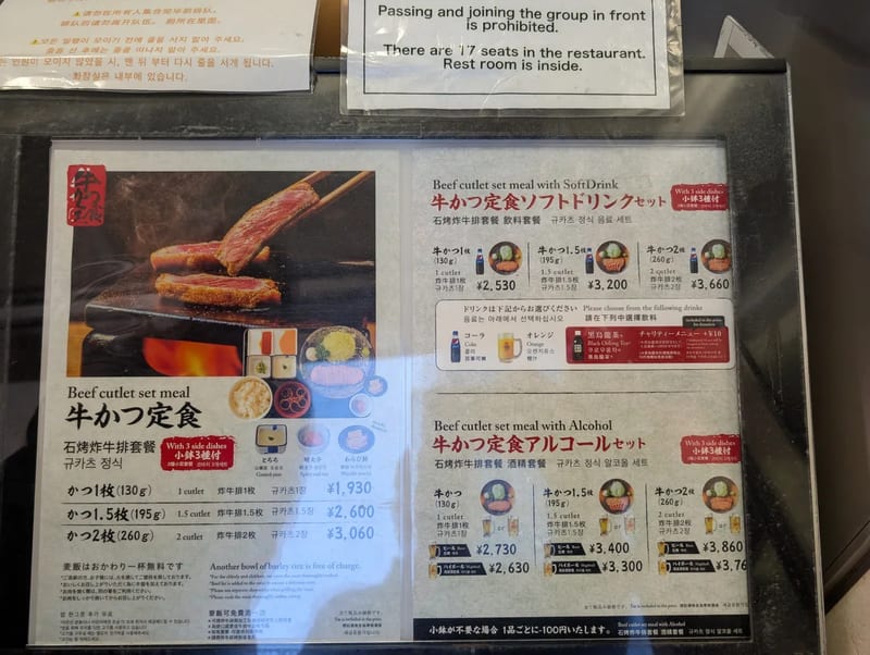 Motomura beef cutlet set menu board with photos and prices in Japanese and English in Tokyo, Japan