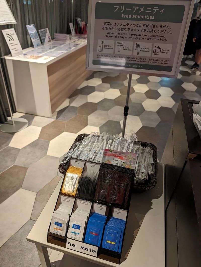Hotel free amenities display with toothbrushes, razors, hairbrushes, and tea bags at Sotetsu Grand Fresa in Osaka, Japan.