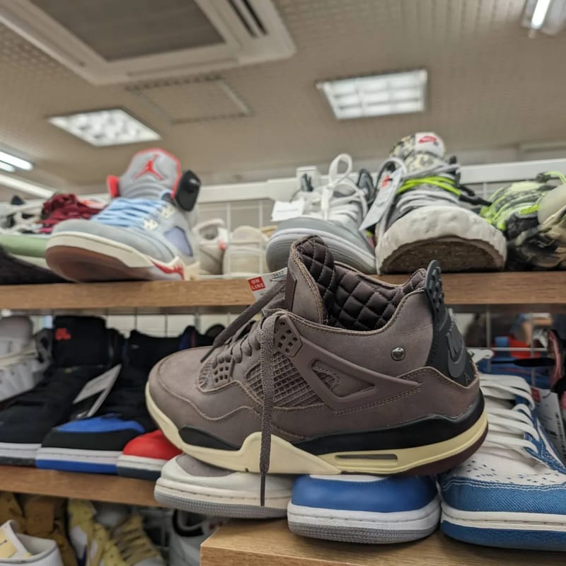 Brown leather Air Jordan 4 sneaker on a shelf at a Japanese second-hand store.