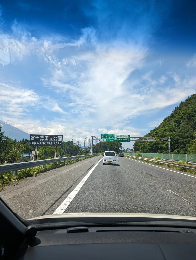 Highway sign for Fuji National Park with Mount Fuji visible, Yamanashi, Japan.