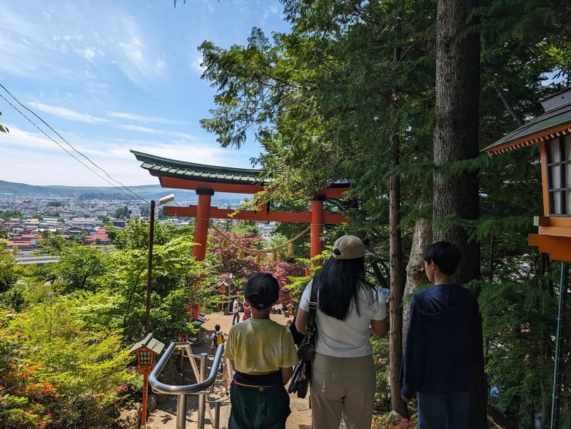 People walking through torii gate path at Arakurayama Sengen Park in Fujiyoshida, Yamanashi, Japan.