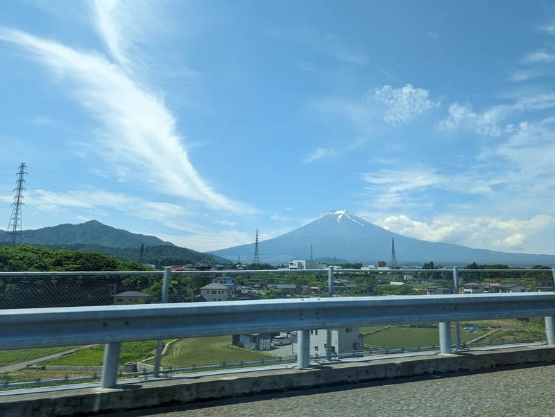 Panoramic view of Mount Fuji over residential area from a highway in Yamanashi, Japan.