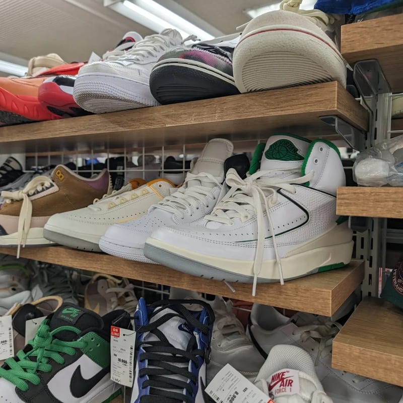 White and green Air Jordan sneakers on a shelf at Second Street resale store in Japan.