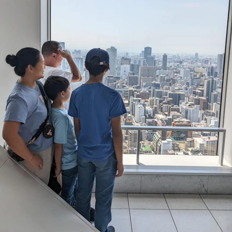 Family looking out over Osaka, Japan from the Umeda Sky Building observation deck.