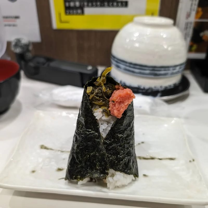 Onigiri with pickled green vegetables and pink roe at Onigiri Gorichan in Osaka, Japan.