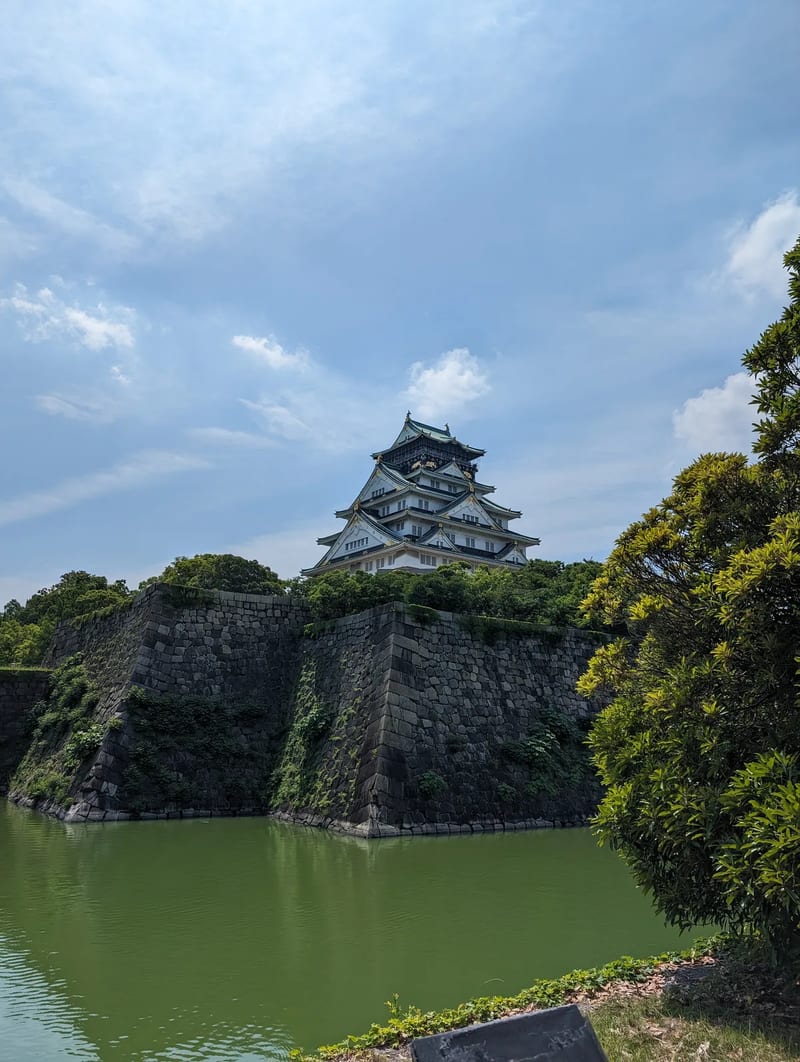 Osaka Castle main tower rising above the stone wall in Osaka, Japan.