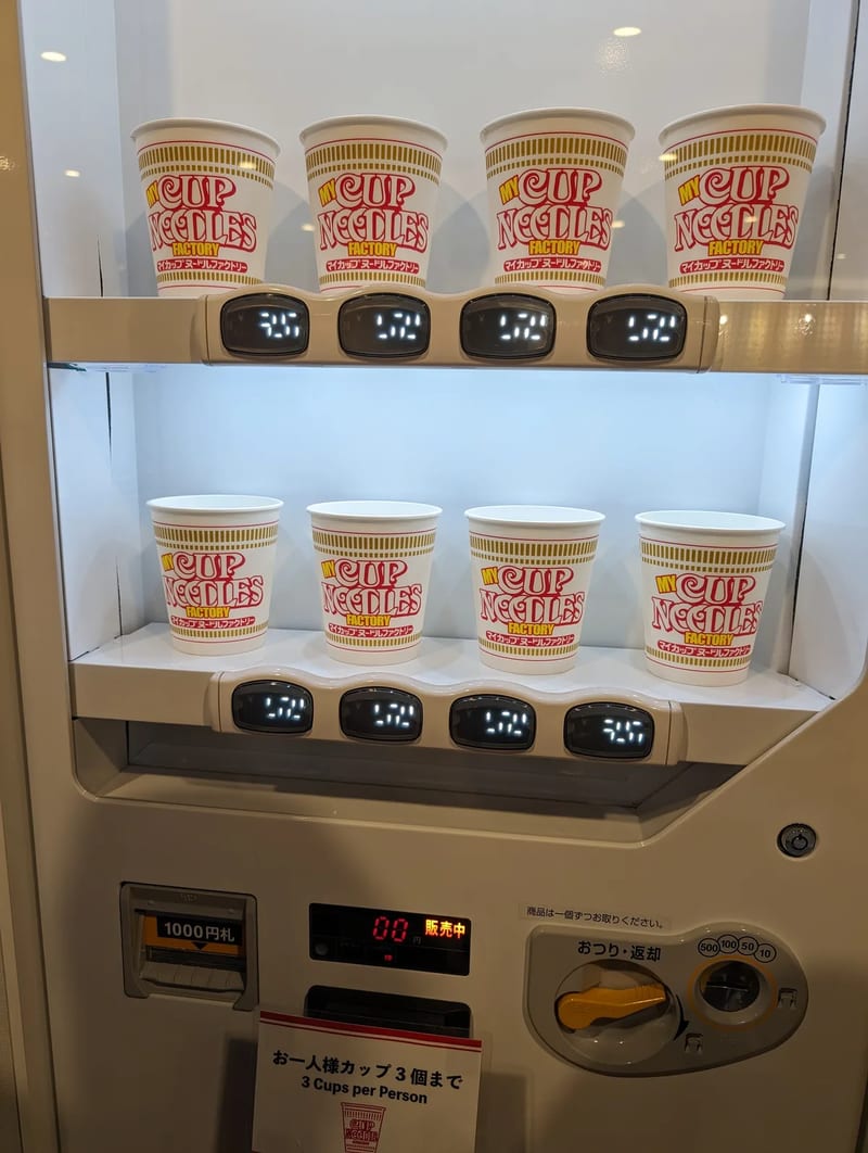 Sealed custom Cup Noodles cups on a tray at My Cup Noodles Factory, Osaka, Japan.