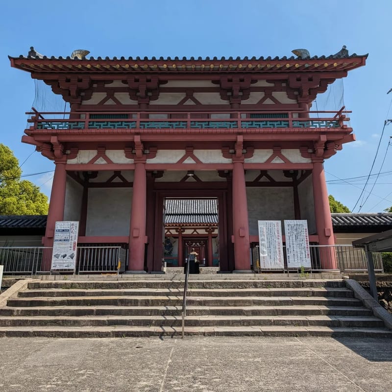 Grand red wooden gate with stone steps at Shitennoji Temple in Osaka, Japan.