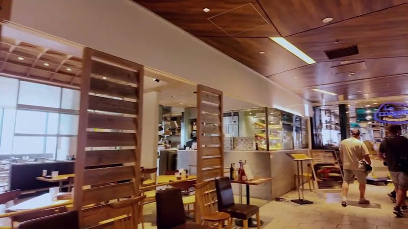 Interior of the 13th floor restaurant area at Shibuya Sky, Shibuya, Tokyo, Japan, with modern wooden accents, warm lighting, and large windows.