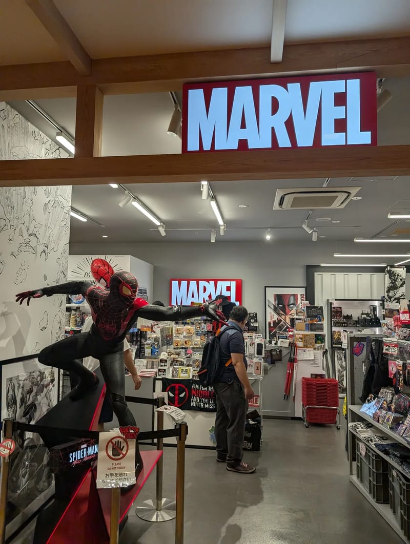 Life-sized Spider-Man Miles Morales statue inside a Marvel store with the MARVEL logo illuminated above, Solamachi, Tokyo, Japan.