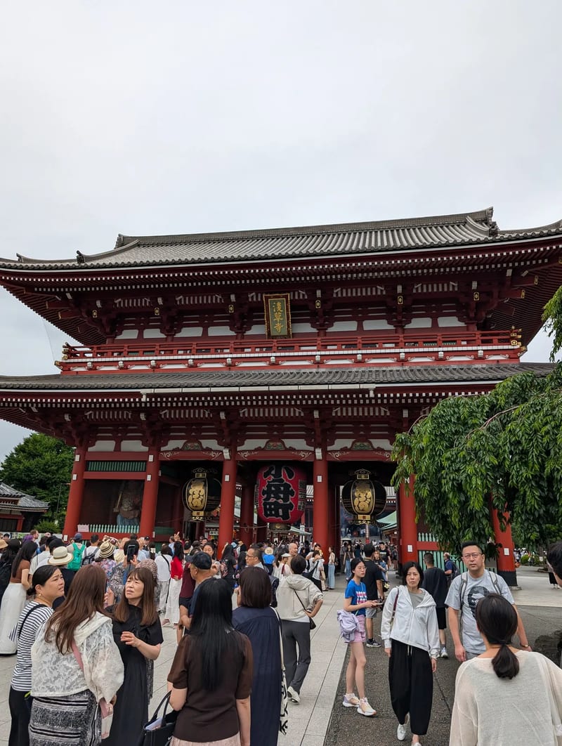 Crowds gathered in front of the red Hozomon Gate at Senso-ji Temple with its iconic giant red lantern, Asakusa, Tokyo, Japan.
