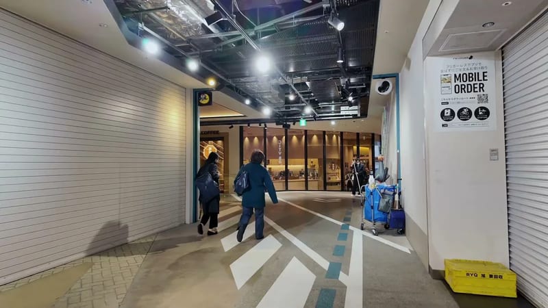 Walking through the ground floor corridor of Hotel Indigo with suitcases heading toward Don Quijote in Shibuya, Tokyo, Japan