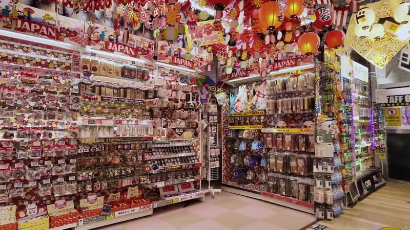 Packed shelves of merchandise and colorful signs with decorative lanterns inside Mega Don Quijote in Shibuya, Tokyo, Japan