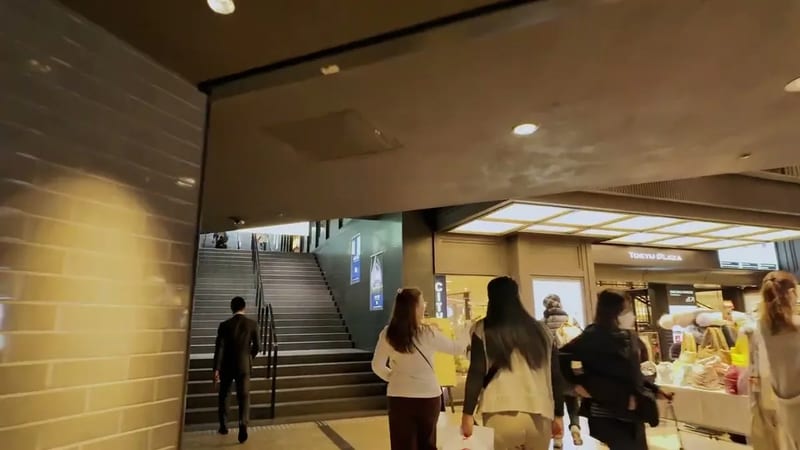 People walking on a modern staircase inside Tokyu Plaza, Ginza, Tokyo, Japan.