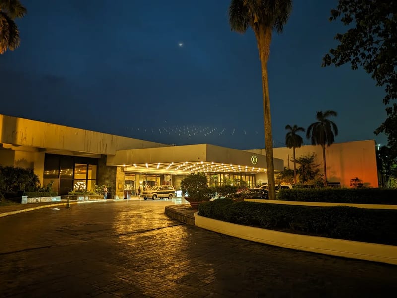 Sofitel Philippine Plaza hotel entrance at dusk with warm lights, a vintage car, and palm trees in Pasay, Metro Manila.
